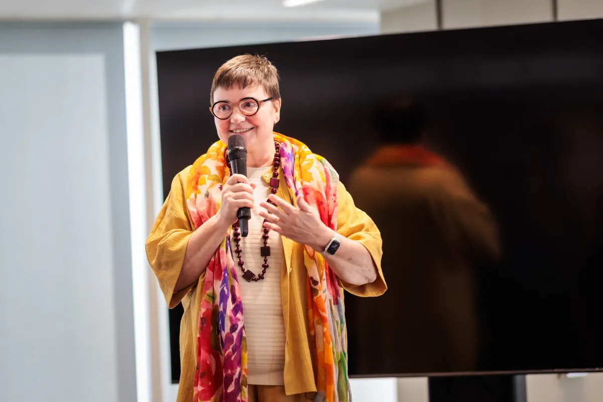 Hilde Vernaillen met microfoon spreekt publiek toe