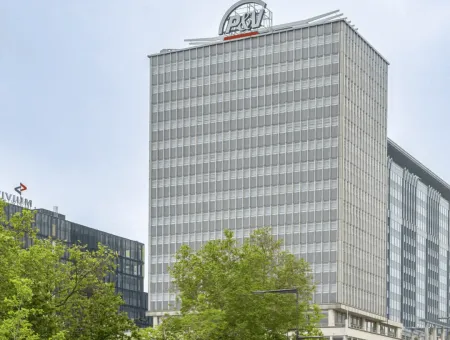 De P&V-toren met een spandoek dat afrolt en deze tekst toont: de modernste wolkenkrabber van Brussel