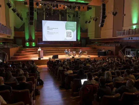 Foto van het publiek en het podium in zaal Flagey tijdens Coopday 2025